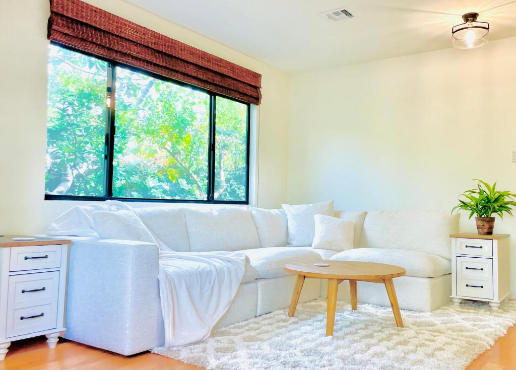 a living room with a white couch and a table at 2 BR 2 BA - Eco House and Garden Vacation Retreat and Remote Workspace for Families, Couples and Solo Travelers in Coveted Culver in Culver City