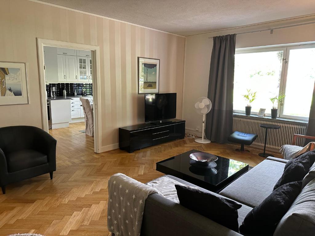 sala de estar con sofá y TV en Pråmkanalens Pensionat i Karlstad, en Karlstad