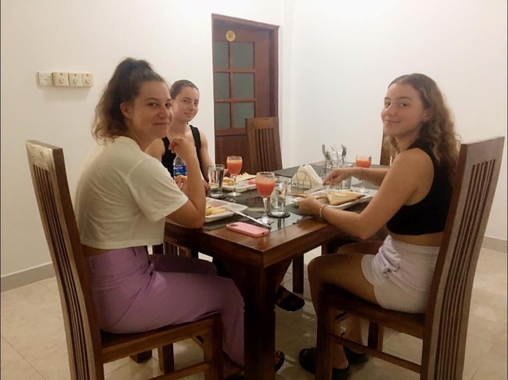 un grupo de tres mujeres sentadas en una mesa en Kavee Transit Hotel en Katunayaka