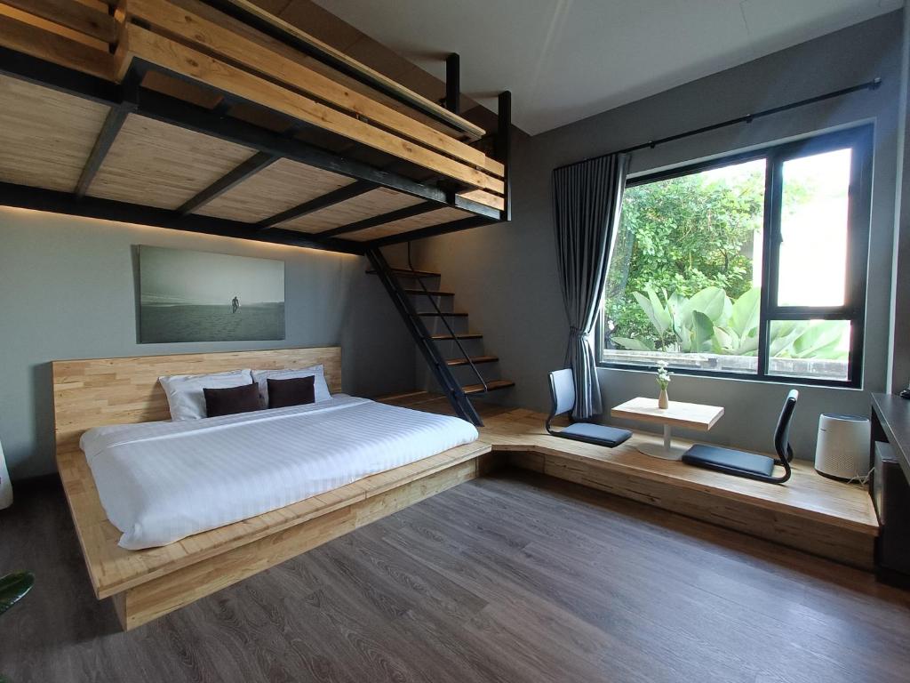 um quarto com uma cama grande e uma janela grande em 233Poshtel em Lampang