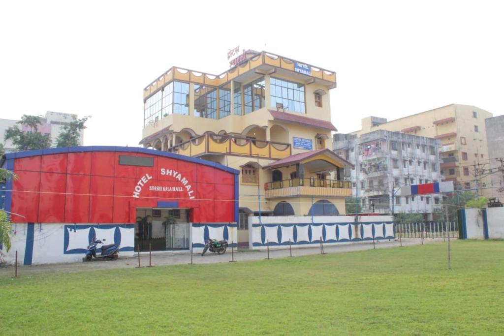 duży budynek przed trawnikiem w obiekcie HOTEL SHYAMALI AND EVENTS w mieście Dhanbad