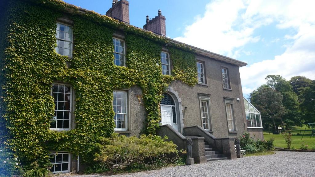 an ivycovered building with stairs and windows at Newrath House X91 DK 4V in Waterford