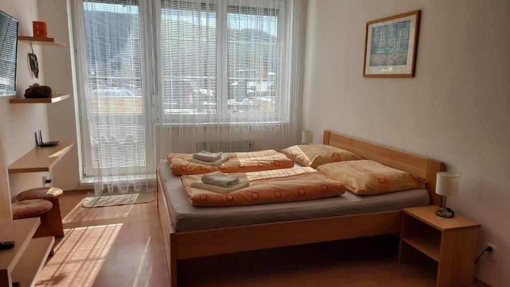 a bedroom with a bed with two pillows on it at Apartment Magura in Donovaly