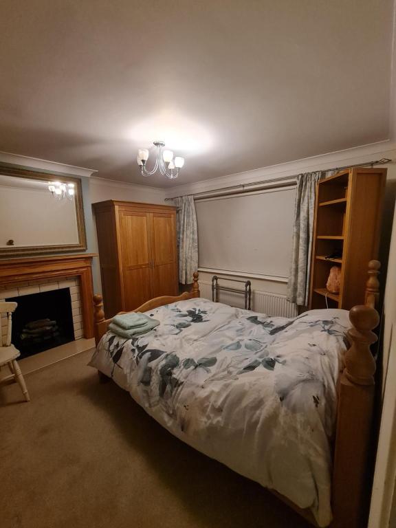 a bedroom with a bed and a fireplace at Double Room near Airport in Takeley