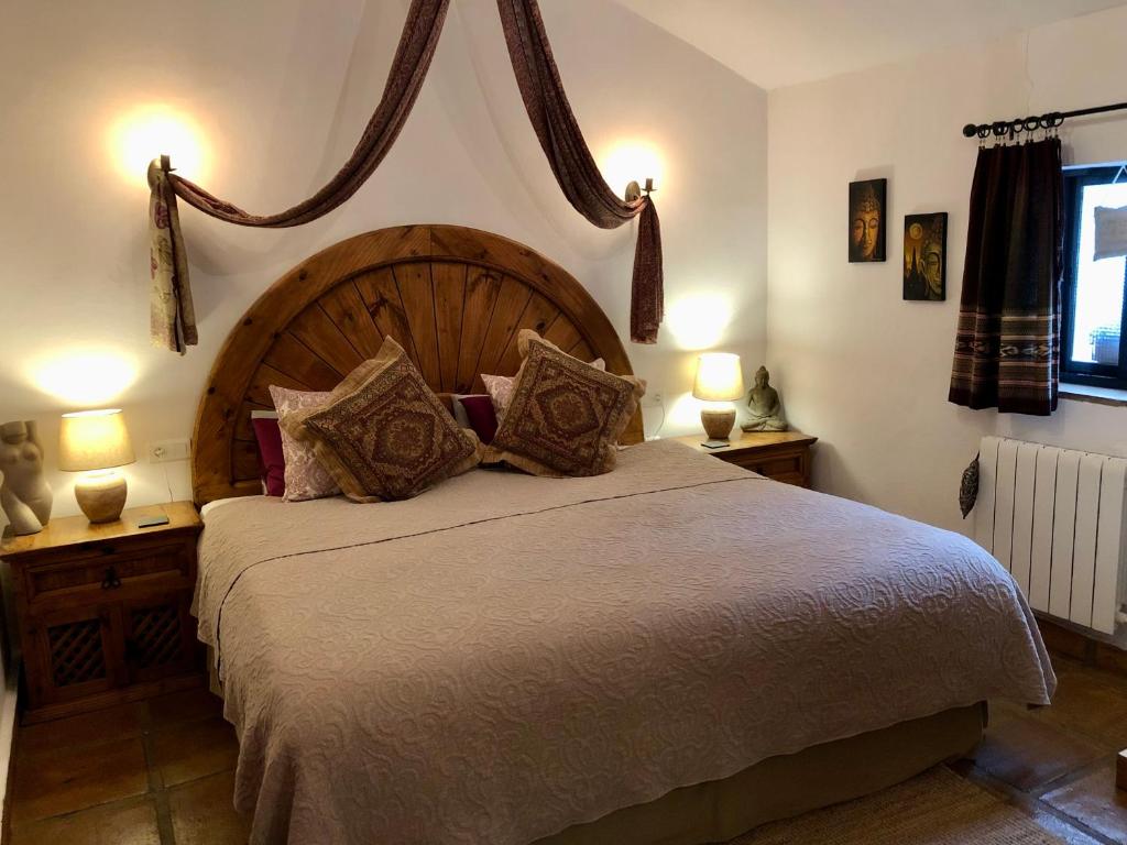 a bedroom with a large bed and two lamps on tables at Finca Las Campanas II in Villanueva de la Concepción