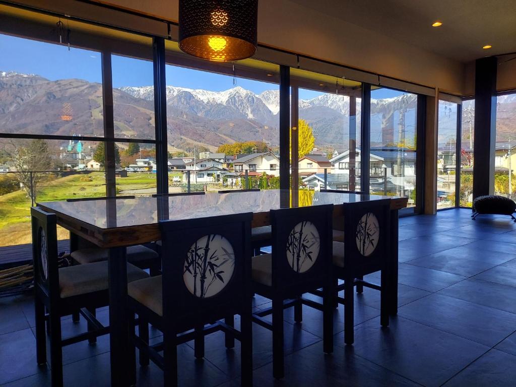 a dining room with a table and chairs and mountains at The Views Hakuba in Hakuba