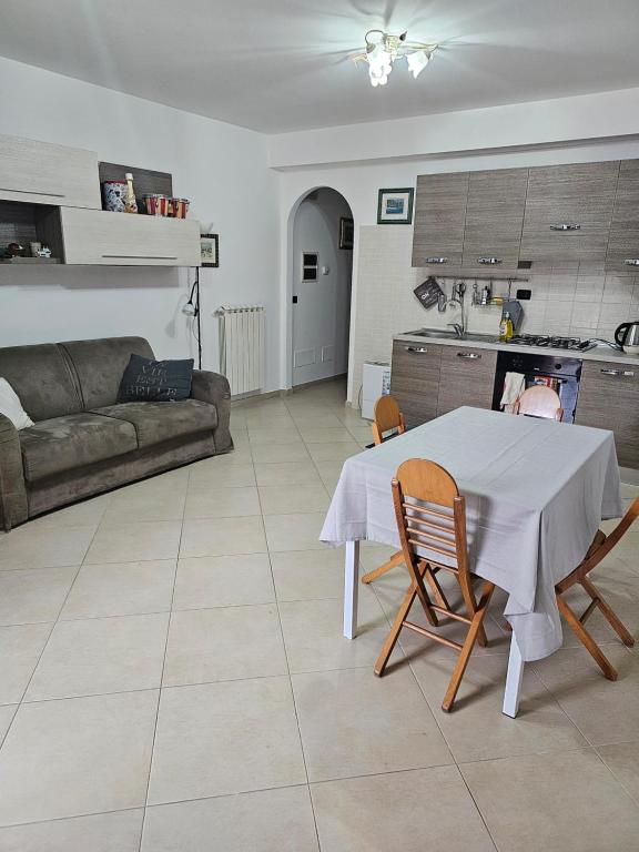 eine Küche und ein Wohnzimmer mit einem Tisch und Stühlen in der Unterkunft Dolce Riposo in Manziana