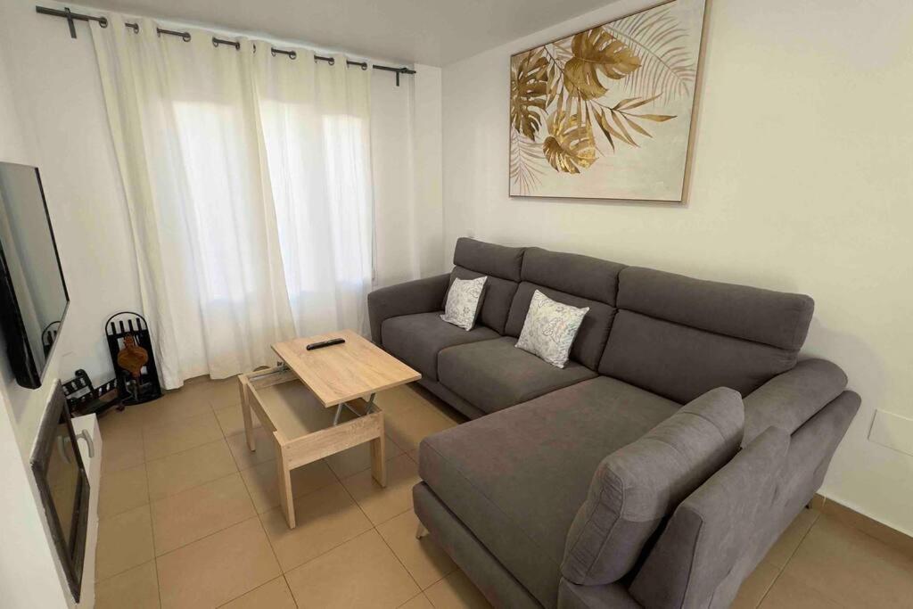 un soggiorno con un divano e un tavolo di Chalet Adosado Cerca Gibraltar a Alcaidesa