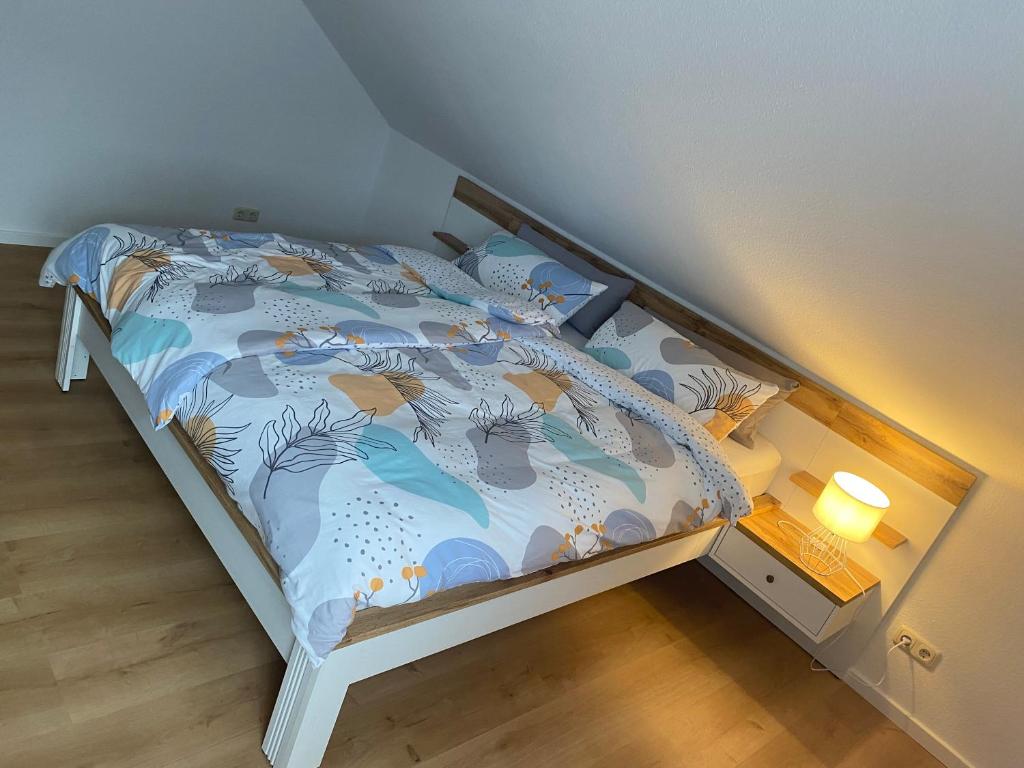 a small bed with a blue comforter and a lamp at Ferienwohnung Blumenau in Bad Berneck im Fichtelgebirge