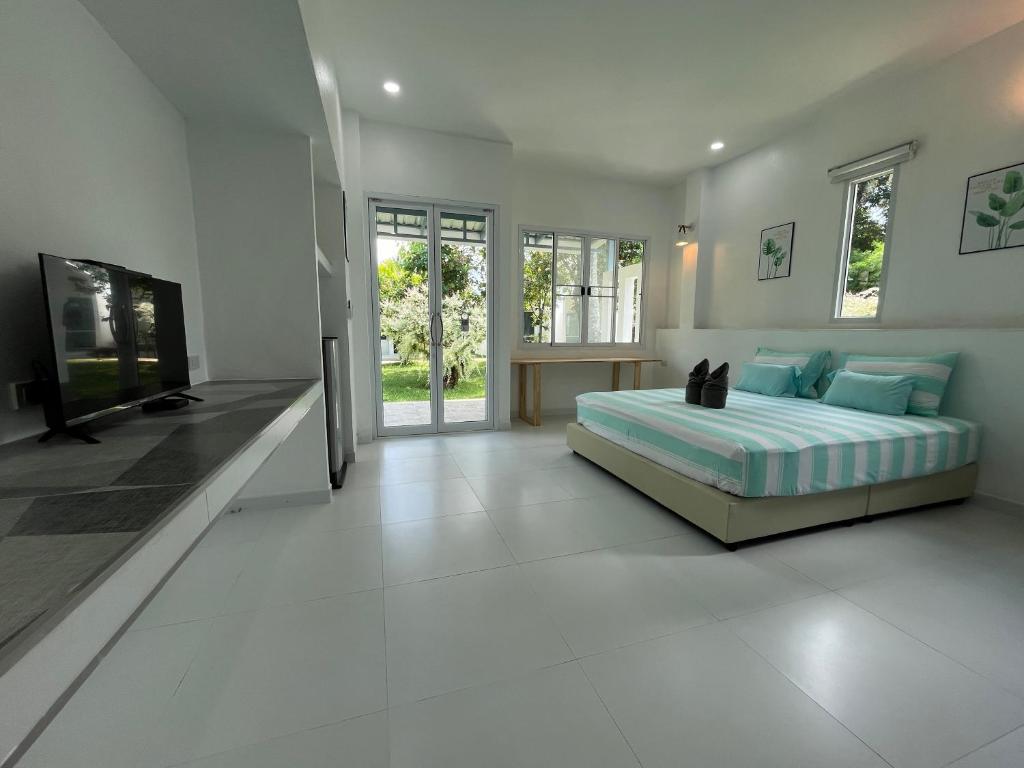 a bedroom with a bed and a flat screen tv at Mook Ing Lay in Ko Mook