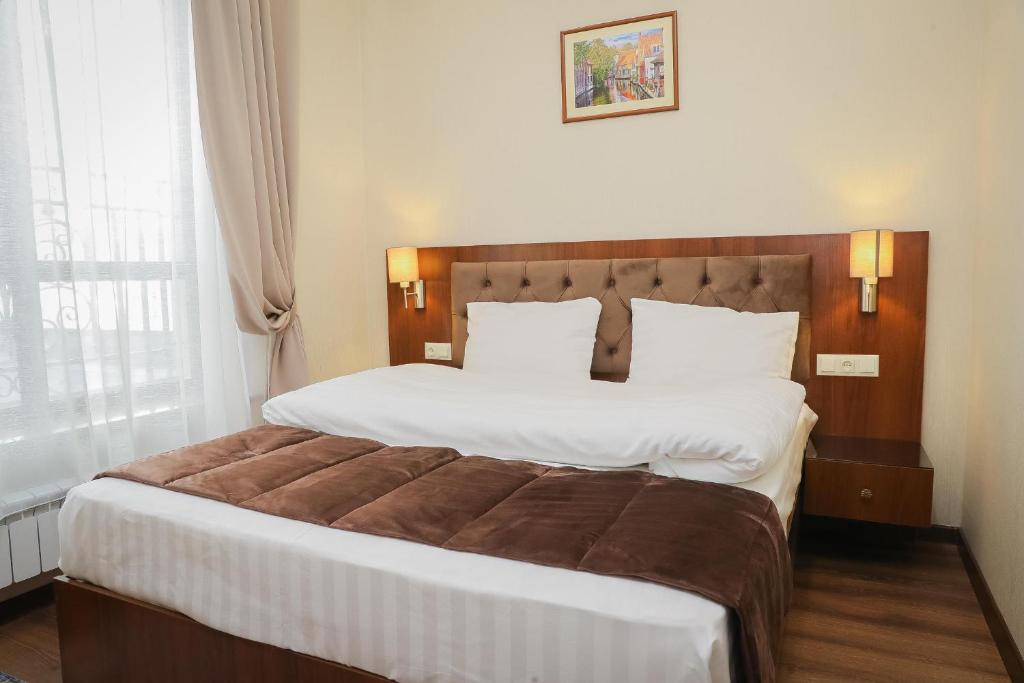 ビシュケクにあるRivieraのベッドルーム(白いシーツを使用した大型ベッド1台付)