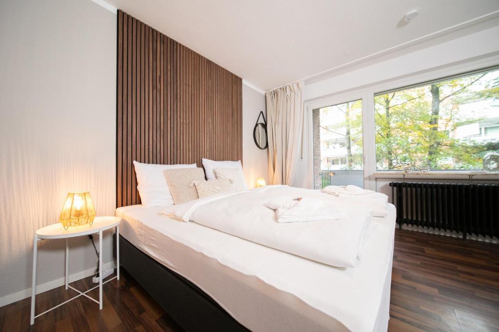 諾伊斯的住宿－Favorite Stays - Suite and More - Westfeld，卧室设有一张白色大床和一扇窗户。