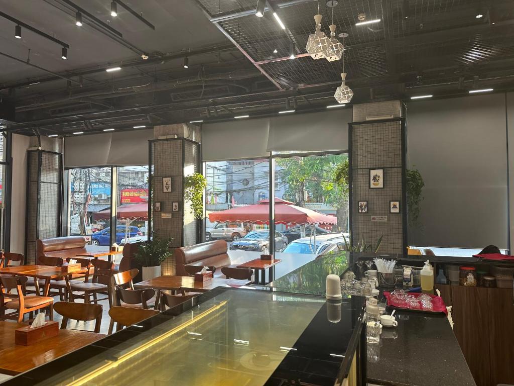 un restaurante con bar, mesas y sillas en A25 Hotel - 18 Nguyễn Hy Quang, en Hanói