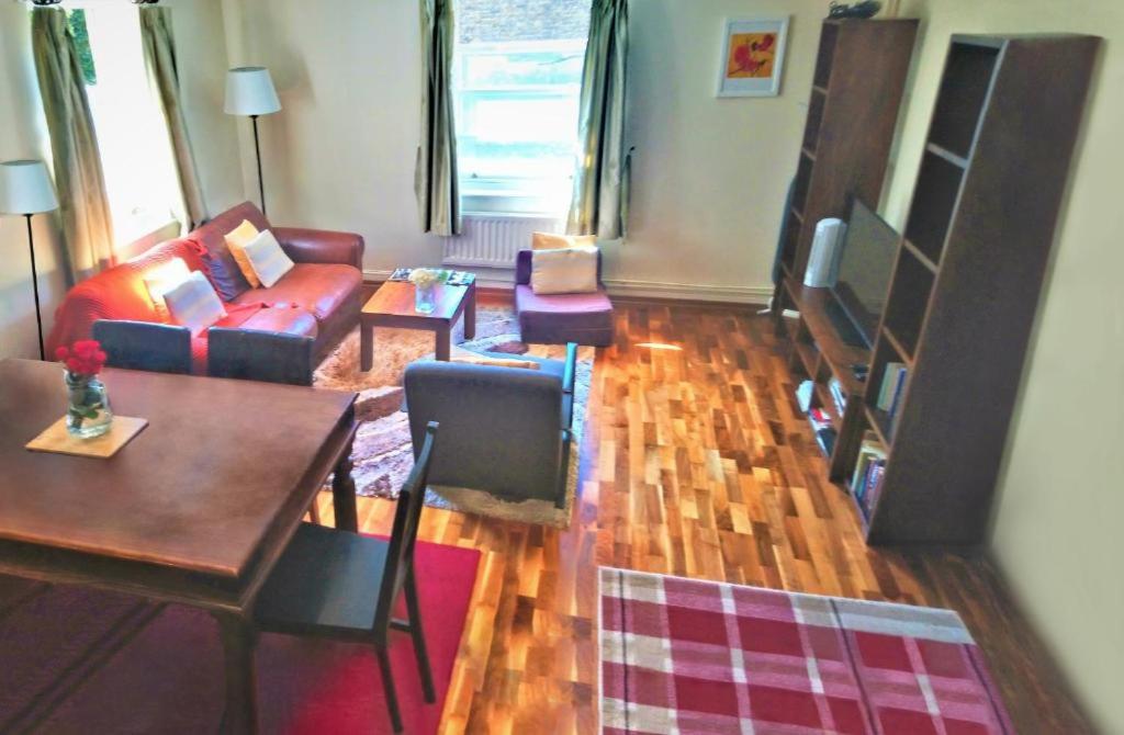 ein Wohnzimmer mit einem Sofa und einem Tisch in der Unterkunft Lovely Apartments by Chelsea in London