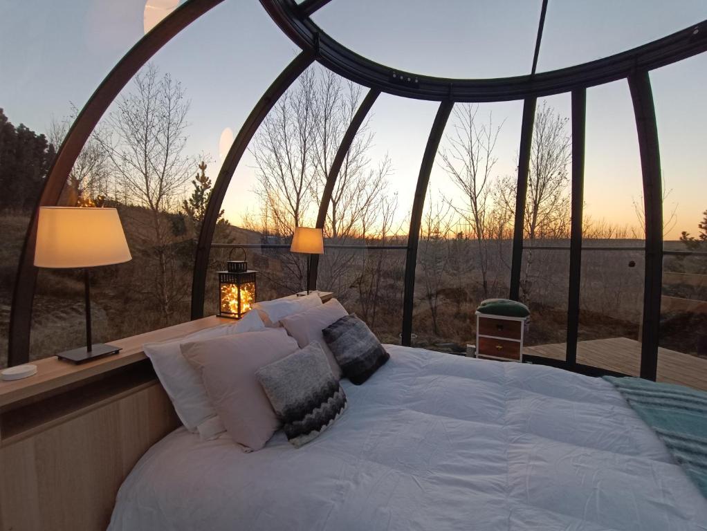 a bed in a gazebo with a view at Cottage with Glass Bubble and Hot tub in Reykholt
