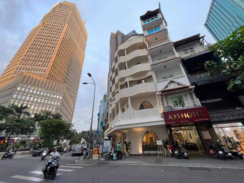 a building on a city street with tall buildings at A25 Hotel - 35 Mạc Thị Bưởi in Ho Chi Minh City