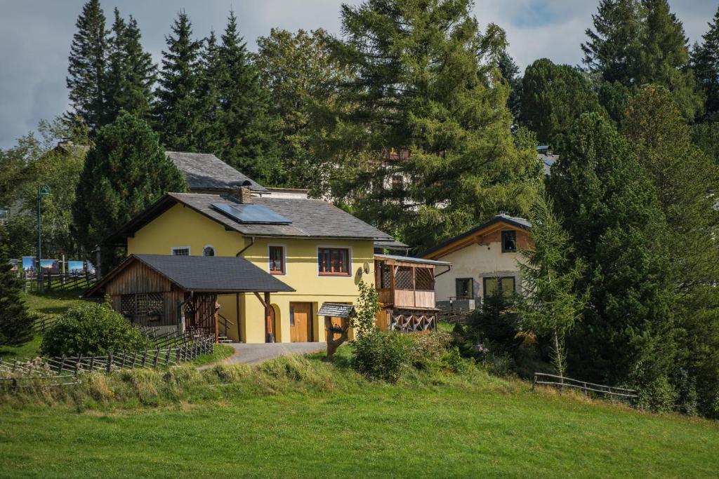 una gran casa amarilla en una colina con árboles en Ferienhaus Seetaler Alpen, en Obdach
