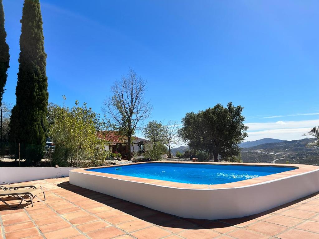 a large swimming pool with a boat on a patio at Casa Pura Vida - Malaga - Andalusië in Colmenar