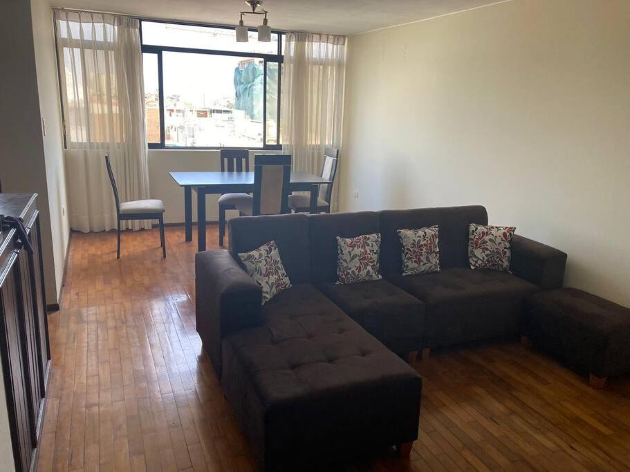 Apartamento en Pueblo Libre في ليما: غرفة معيشة مع أريكة وطاولة