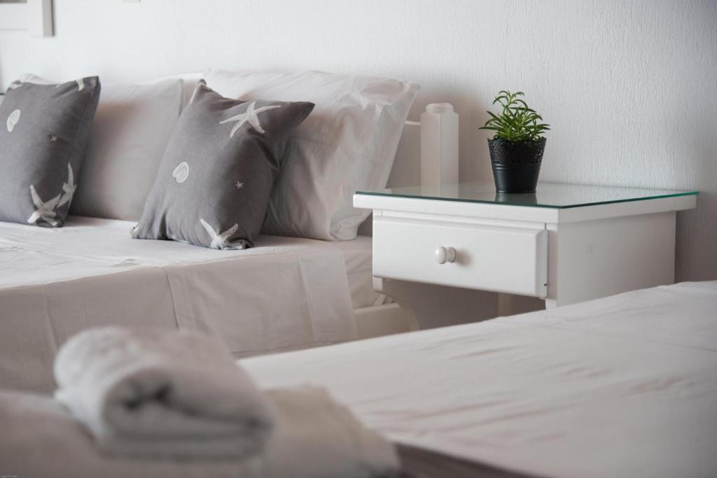 a bedroom with a bed and a table with a plant on it at Fisilanis Beachfront Hotel in Logaras