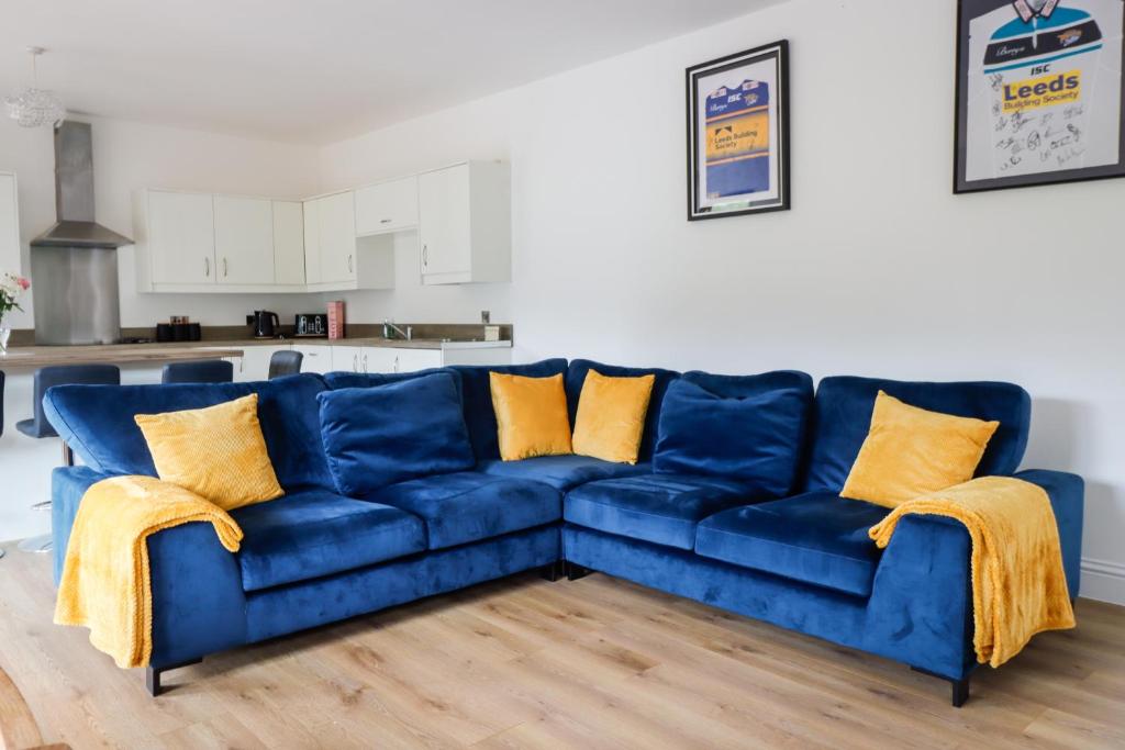 a blue couch in a living room with yellow pillows at Stunning Lodge with Hot Tub on Private Lake in Harrogate