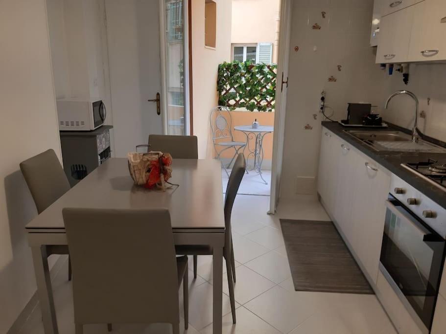 Hotel Casa di Ermy, a kitchen with a table and chairs and a counter top at Casa di Ermy in Sanremo