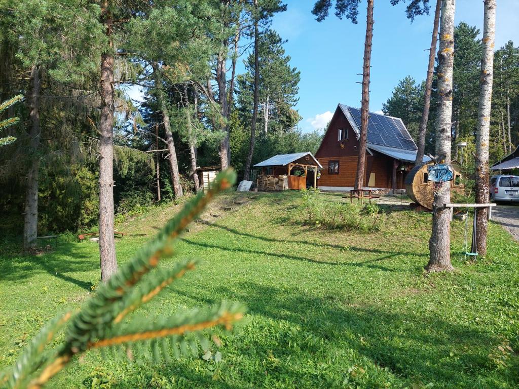 a log cabin in the woods next to a house at Cottage Tatry so saunou in Tatranska Strba