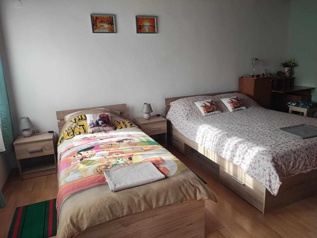 1 dormitorio con 2 camas y ordenador portátil en la cama en Apartman 1 RIBIČ, en Ogulin