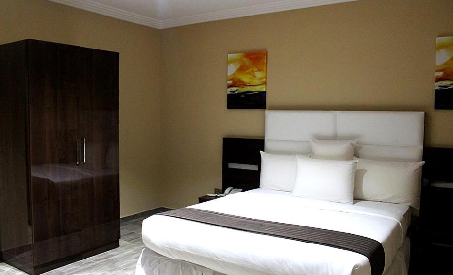 Postel nebo postele na pokoji v ubytování Ellyxville Hotel