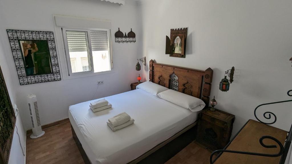 1 dormitorio con 1 cama con sábanas blancas y ventana en Apartamento Jerez Centro, en Jerez de la Frontera