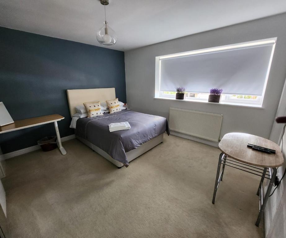 een slaapkamer met een bed, een raam en een stoel bij Polkerris Way 1 in Fleet