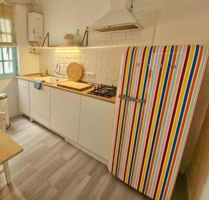 a kitchen with a refrigerator with a colorful striped door at Paraíso Las Galanas 2ROOMS in San Sebastián de la Gomera
