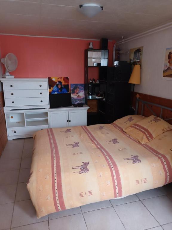 a bedroom with a large bed and a dresser at Au bon vivre in Lempdes