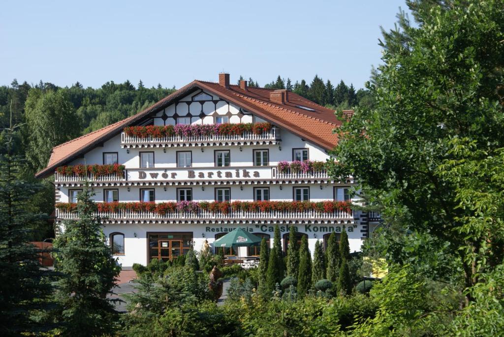 a large white building with a red roof at Dwór Bartnika in Narewka