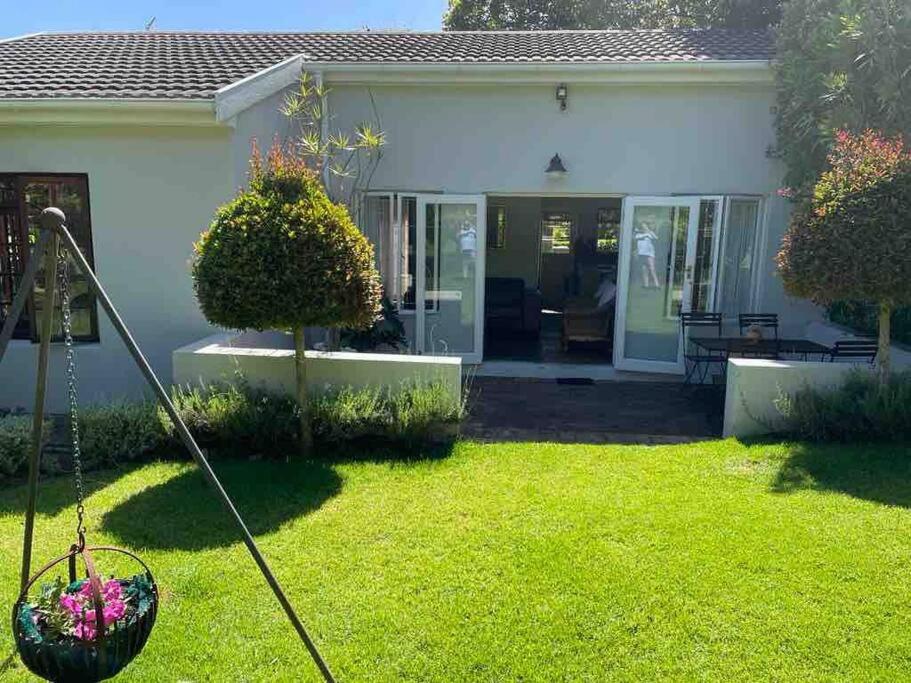 a yard with a house with a lawn mower at Charming 2 Bed en-suite Cottage with Solar in Cape Town