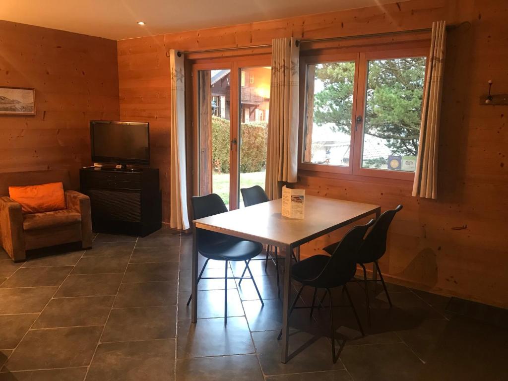 a dining room with a table and chairs and a television at Chalet Hestia in Champéry