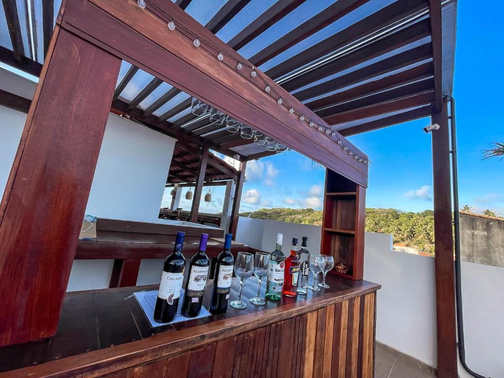 a bar with wine bottles and glasses on a balcony at Residence Pipa Beach in Pipa