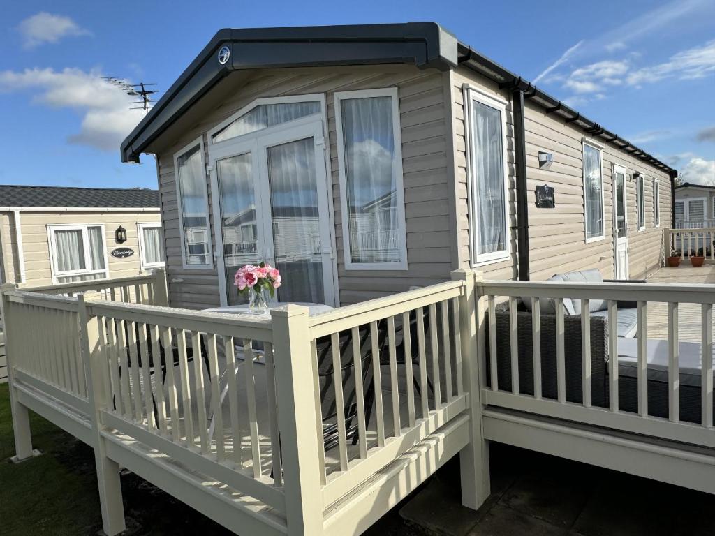 a tiny house with a white railing and a porch at Beautiful 2-Bed Holiday home in Whitstable