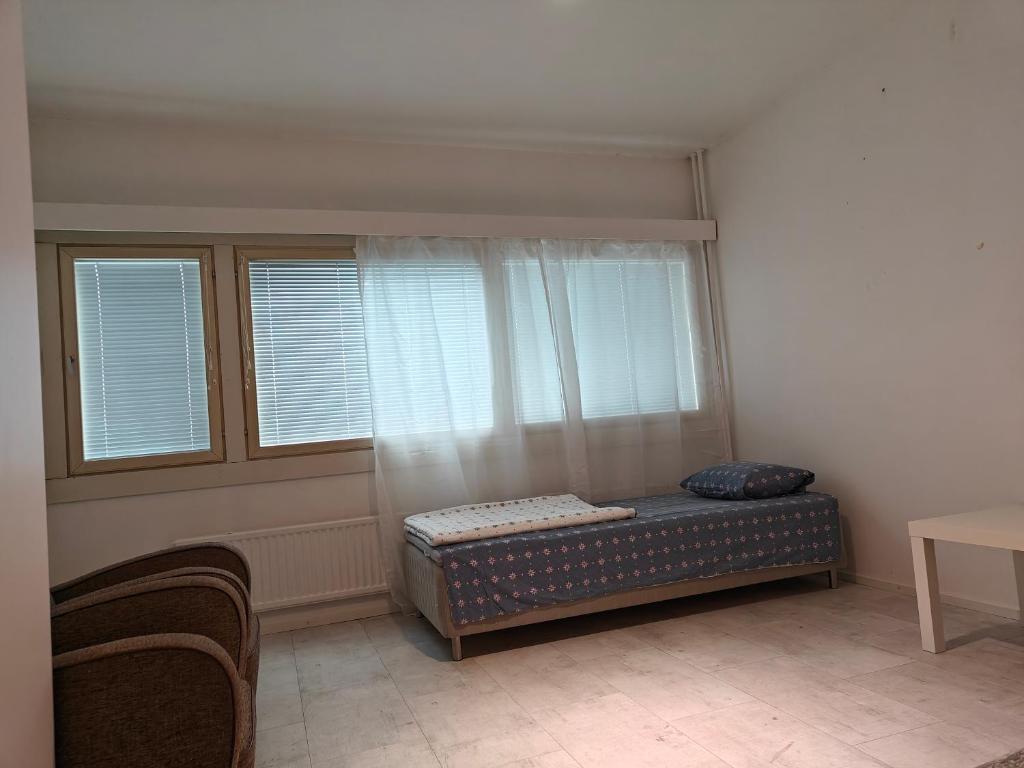 een kamer met een bed en 2 ramen bij Nest Hostel in Turku