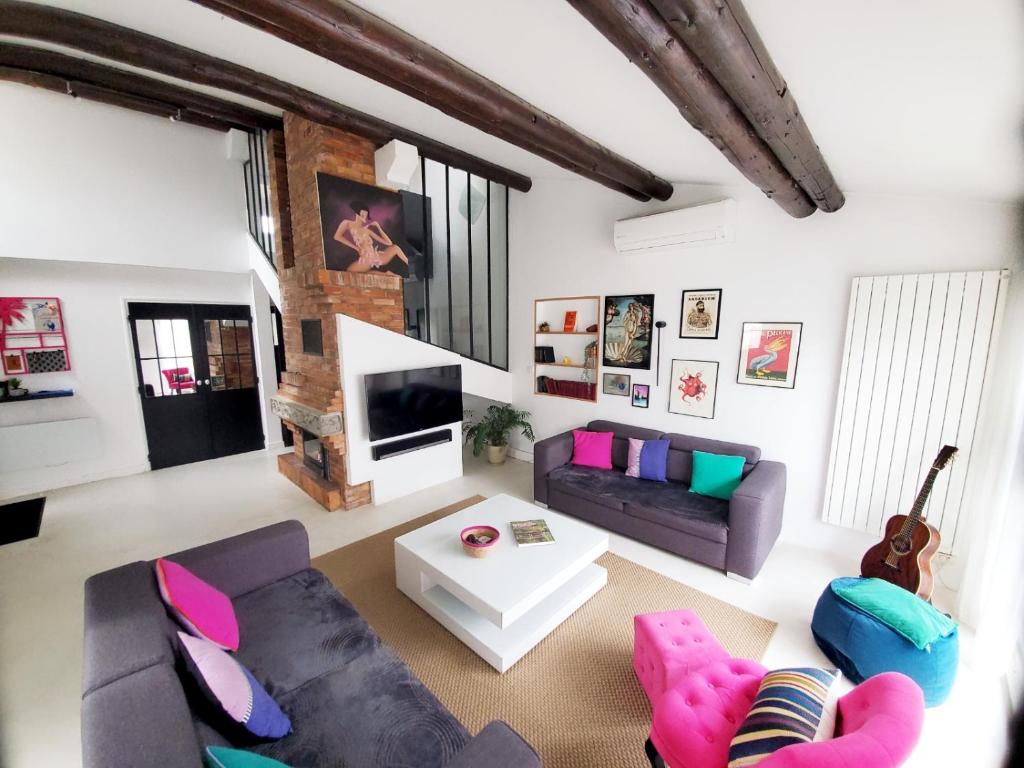 ein Wohnzimmer mit 2 Sofas und einem TV in der Unterkunft The Cosy House in Périgny