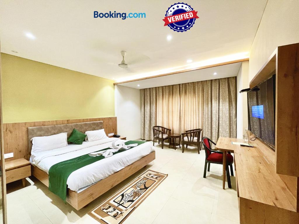 um quarto de hotel com uma cama e uma sala de jantar em Hotel Rockbay-near sea beach & temple em Puri