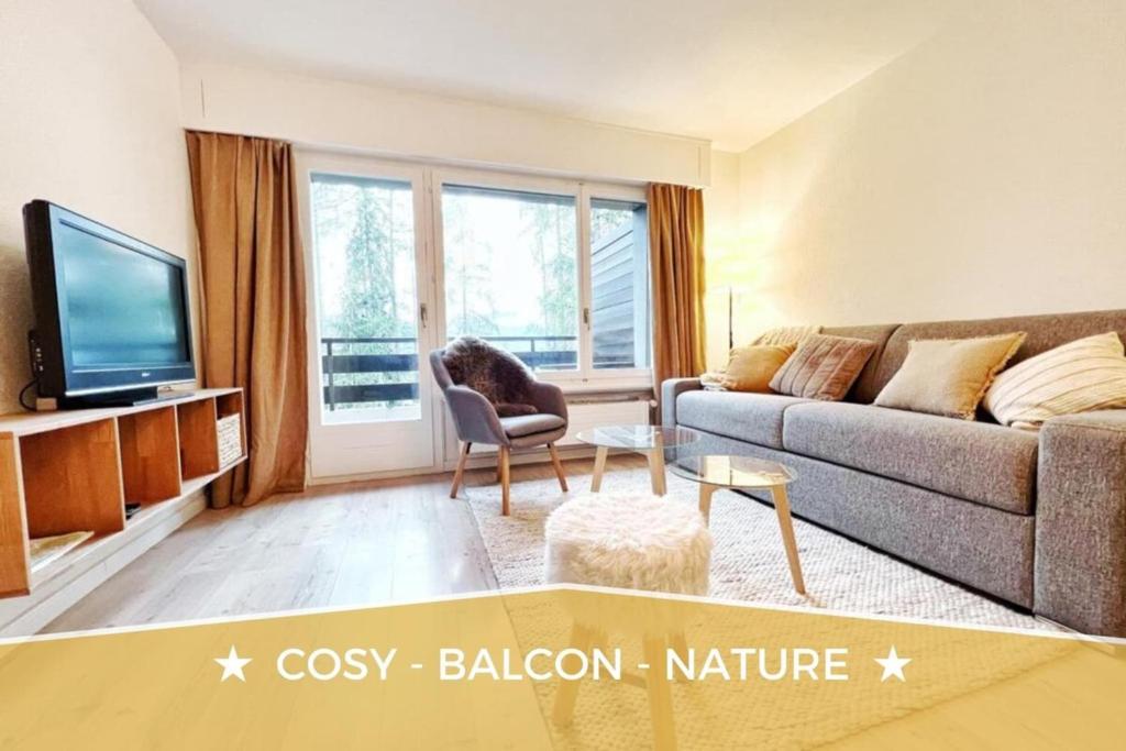 uma sala de estar com um sofá e uma televisão em Brin de Mousse I 49 m I Balcony I Peace and greenery em Crans-Montana