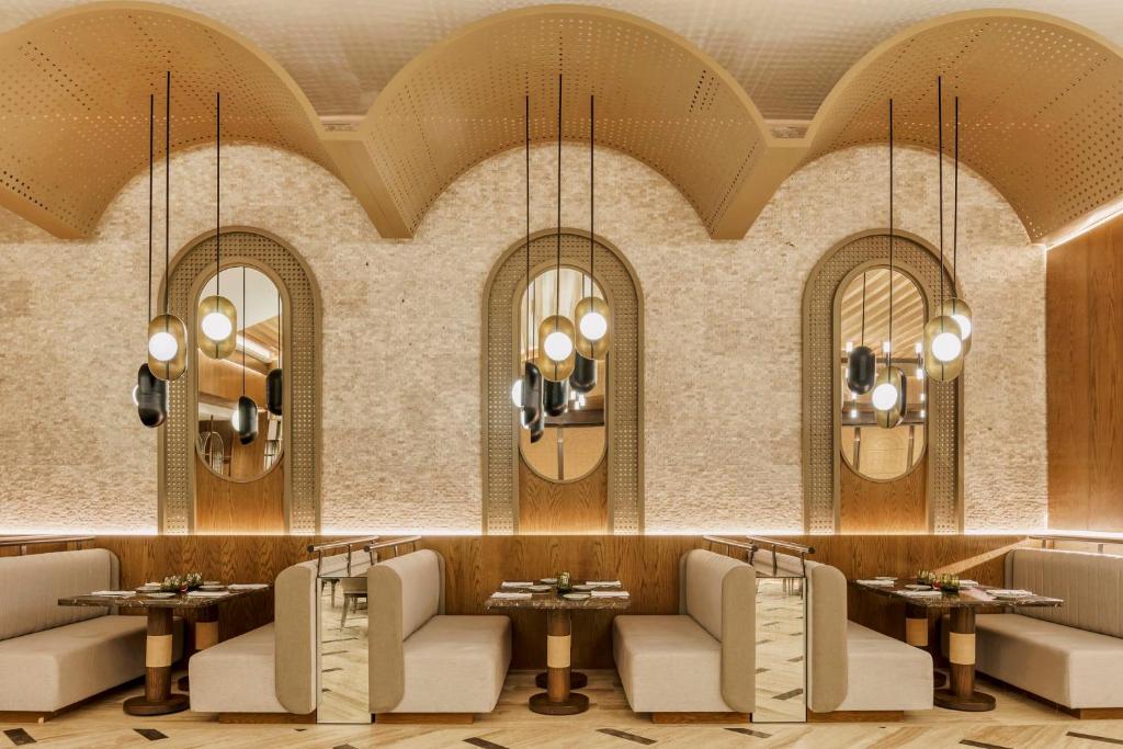 a restaurant with chairs and tables and mirrors at Grand Fiesta Americana Coral Beach Cancun - All Inclusive in Cancún