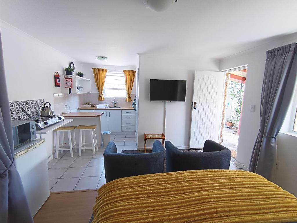 cocina y sala de estar con cama y sillas en NoulAnouk's Corner, en Ciudad del Cabo