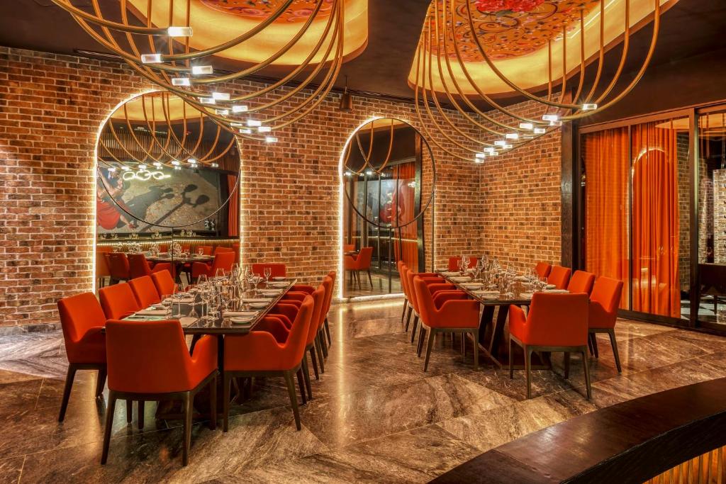 a dining room with tables and red chairs at Grand Fiesta Americana Coral Beach Cancun - All Inclusive in Cancún