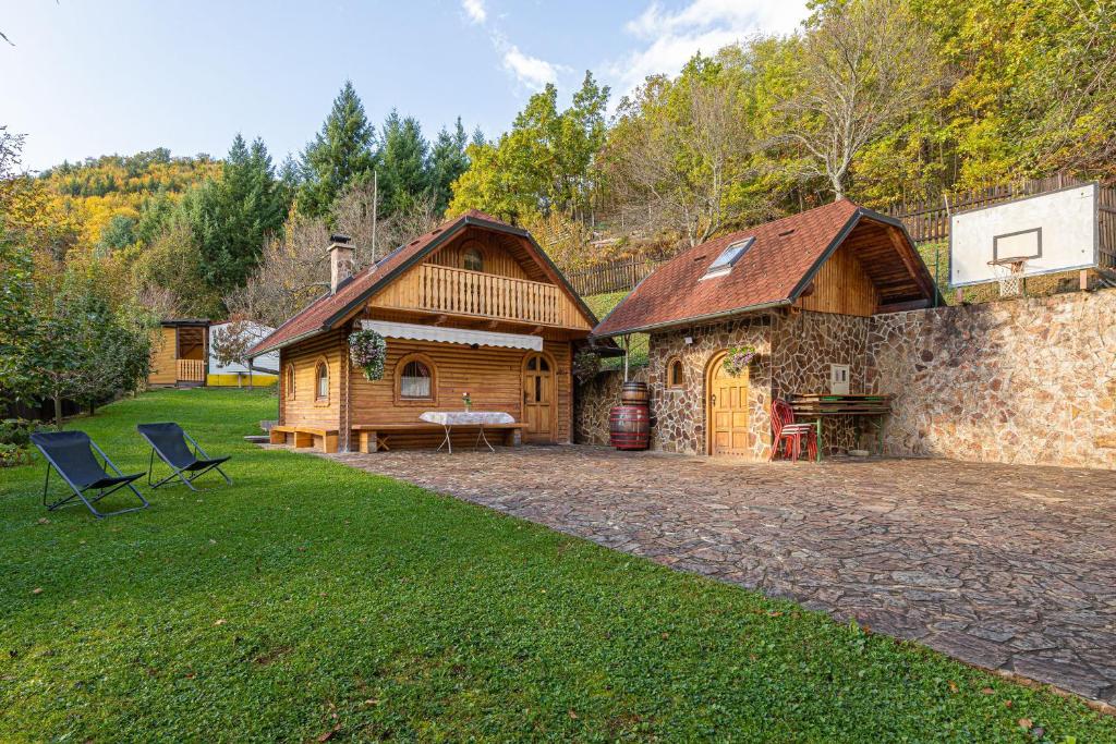 une cabane en rondins avec une table et des chaises dans une cour dans l'établissement Rudnica Hill Lodge - Happy Rentals, à Podčetrtek