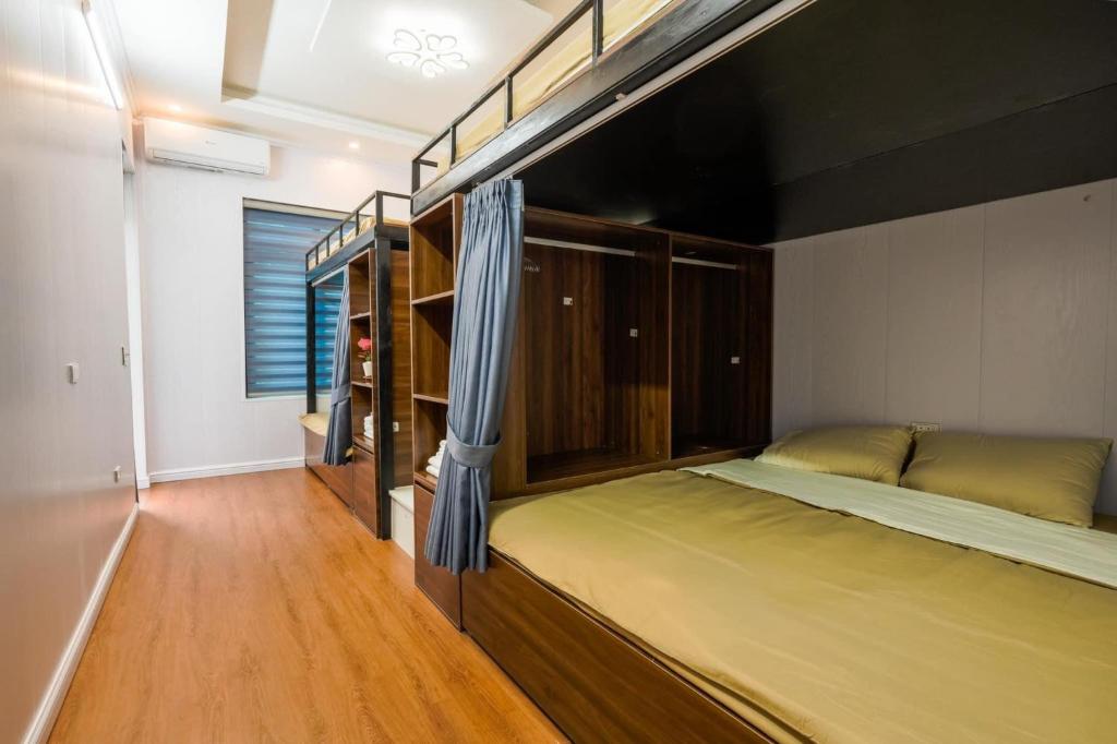 a bedroom with two bunk beds and a wooden floor at Cá Homestay-Cao Bằng in Cao Bằng