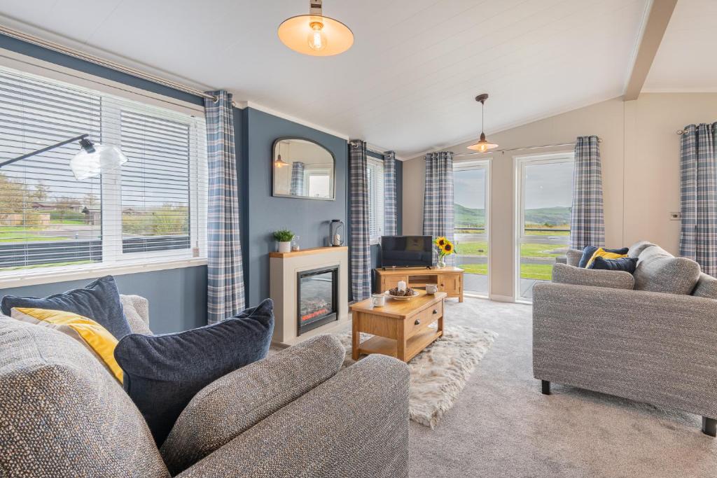 a living room with two couches and a tv at Oak Tree Timber Holiday Lodge in Bassenthwaite
