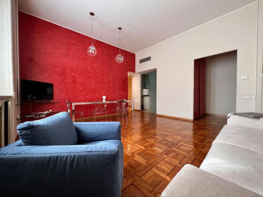 un soggiorno con divano blu e parete rossa di Appartamento in centro a Milano