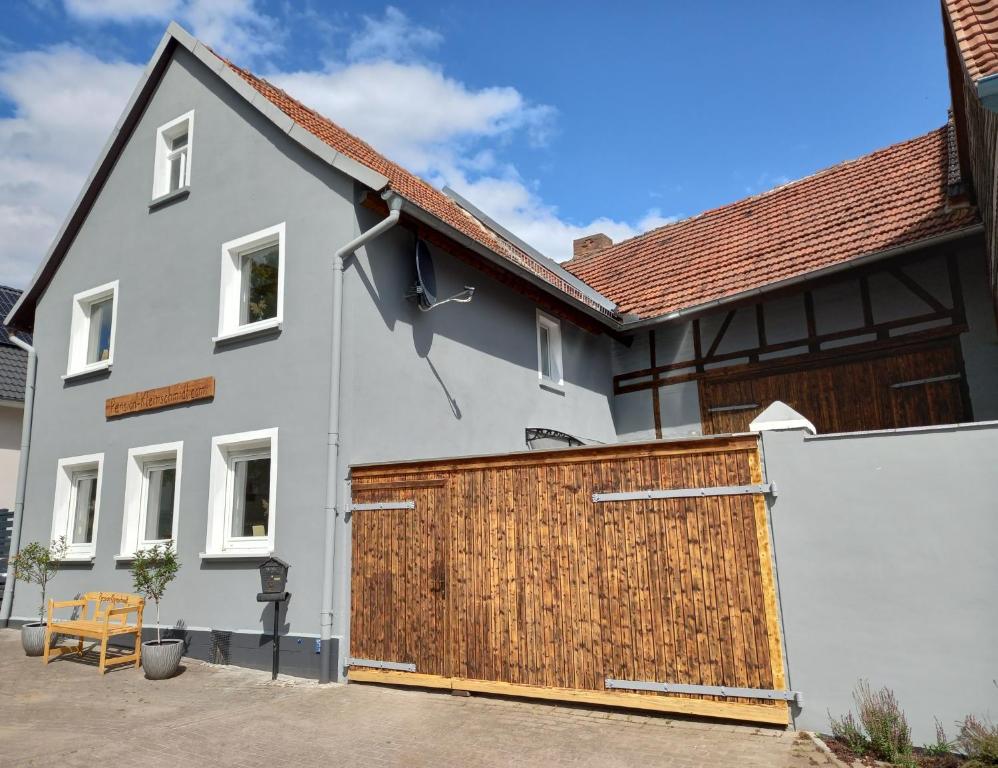 een wit huis met een houten garagedeur bij Pension Kleinschmidt in Urbach